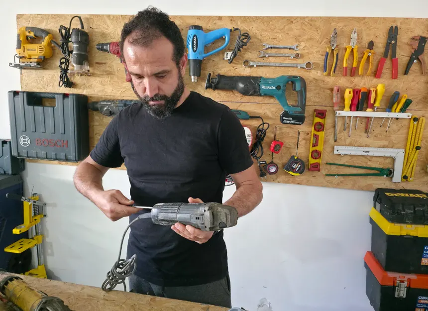 Instrutor realizando manutenção em uma ferramenta elétrica na oficina
